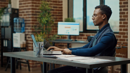 Businesswoman using laptop at table