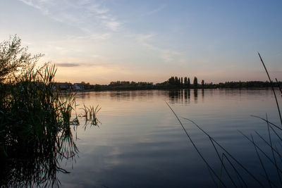 Scenic view of lake against sky at sunset