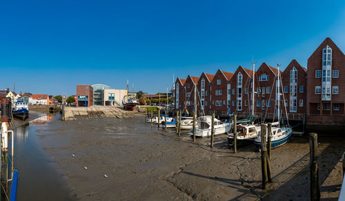 Panoramic view of beach by buildings against blue sky