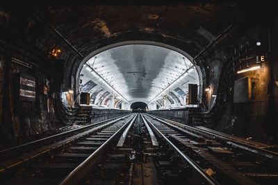 Railroad tracks in illuminated tunnel