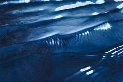 Calm water surface texture with waves in dark blue color. trendy fresh abstract nature background