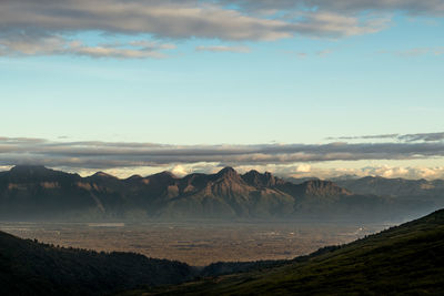 Scenic view of sea and mountains against sky