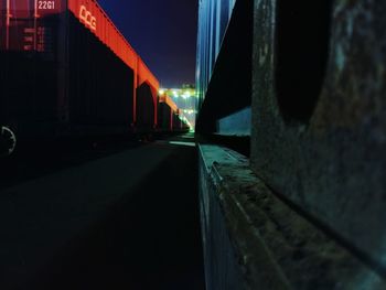 Surface level of road along illuminated bridge at night