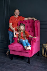 Portrait of young couple sitting on sofa