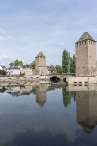 Reflection of built structure in water against sky