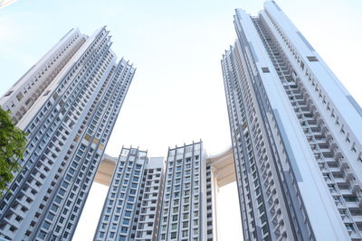 Low angle view of modern high rising buildings with sky bridge link up.