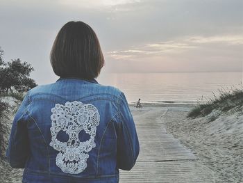 Rear view of woman looking at sea shore against sky