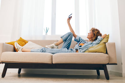 Young woman sitting on sofa at home