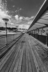 Surface level of empty bridge against sky in city