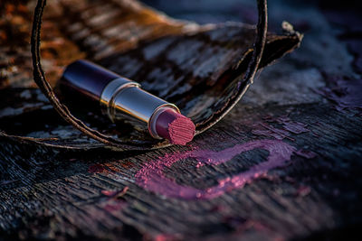 Close-up of pink lipstick on wooden table