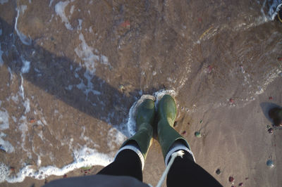 Low section of man standing in water