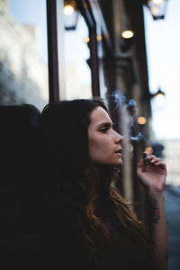 Young woman looking through window