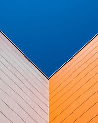 Low angle view of wall against clear blue sky