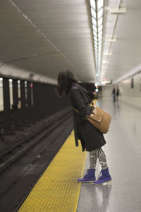 Woman standing on railroad station platform