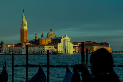 Canal amidst buildings against sky