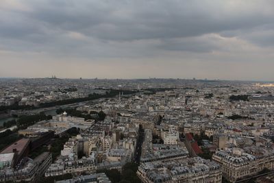 Aerial view of cityscape against cloudy sky