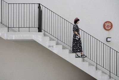 People walking on staircase against wall