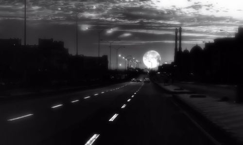 Road passing through city at dusk