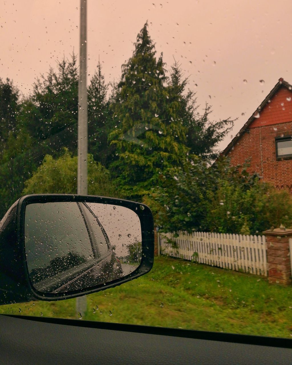 REFLECTION OF CAR ON SIDE-VIEW MIRROR OF RAIN