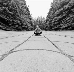 Rear view of man sitting on road against sky