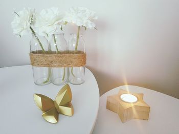 Close-up of white flower vase on table against wall at home