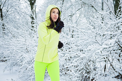 Cold weather running. happy woman running in winter snowy park, forest. running athlete woman