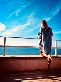 Rear view of woman looking at swimming pool against sea