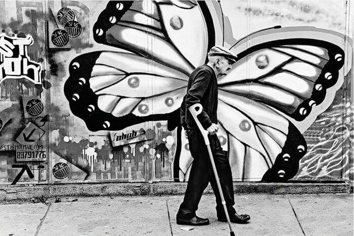 graffiti, lifestyles, standing, art, creativity, art and craft, leisure activity, wall - building feature, low section, casual clothing, full length, shoe, fashion, shadow, person, men, street