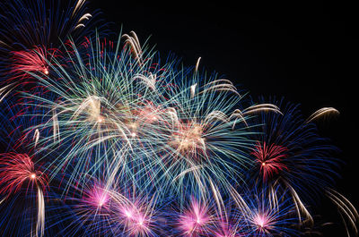 Low angle view of firework display against sky at night