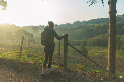 Rear view of woman standing on land against sky