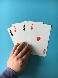 Cropped image of hand with aces cards at casino table