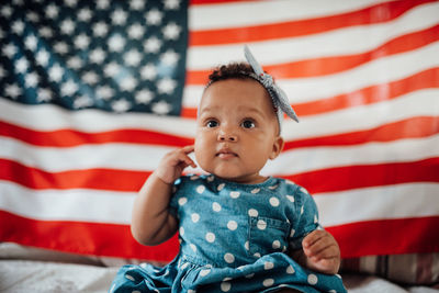 Portrait of cute girl sitting on red flag