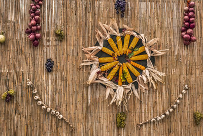 Autumn harvest scene with corn, grapes, garlic and red onion on reed background