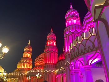 Low angle view of illuminated building against sky at night