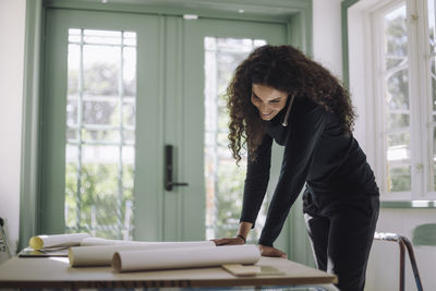 Portrait of young woman sitting on window