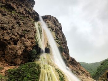 Waterfall on foggy sky