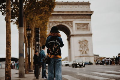 Rear view of people in front of historical building