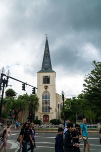 People in front of building against sky