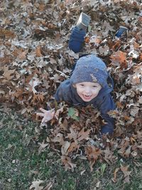 High angle of boy jumping in the leaves
