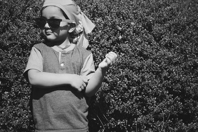 Cute girl wearing sunglasses against plants