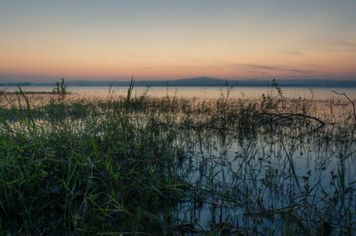 Scenic view of lake against sky during sunset