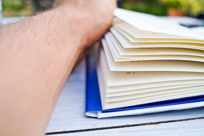 Cropped image of hand with book on table