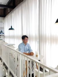 Side view of man standing by railing