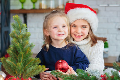 Two sisters playing in christmas kitchen with new years decor