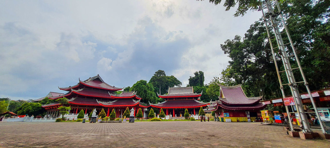 architecture, religion, temple - building, built structure, belief, travel destinations, sky, travel, cloud, nature, tree, building, tradition, plant, temple, spirituality, building exterior, tourism, history, ancient, the past, place of worship, outdoors, arts culture and entertainment, city, environment, pagoda, roof, red, landscape, tourist