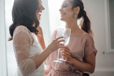 Bridesmaid and bride holding champagne flute