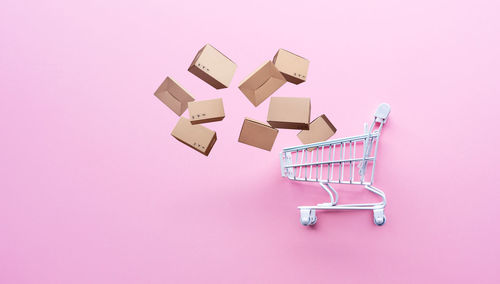 High angle view of toys on paper against pink background