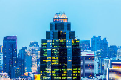 Modern buildings in city against clear blue sky