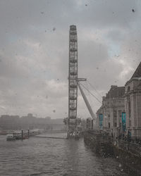 Cranes in city against sky