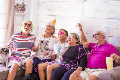 Senior friends partying with grandson at home